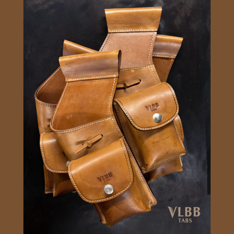 Leather archery quivers: field, back and hip quivers explained 1 Several tan VLBB field quivers with brass-stud accessory pouches, grouped together