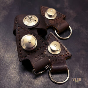 Four VLBB arrowhead-shaped leather key fobs with metal snap studs and key rings
