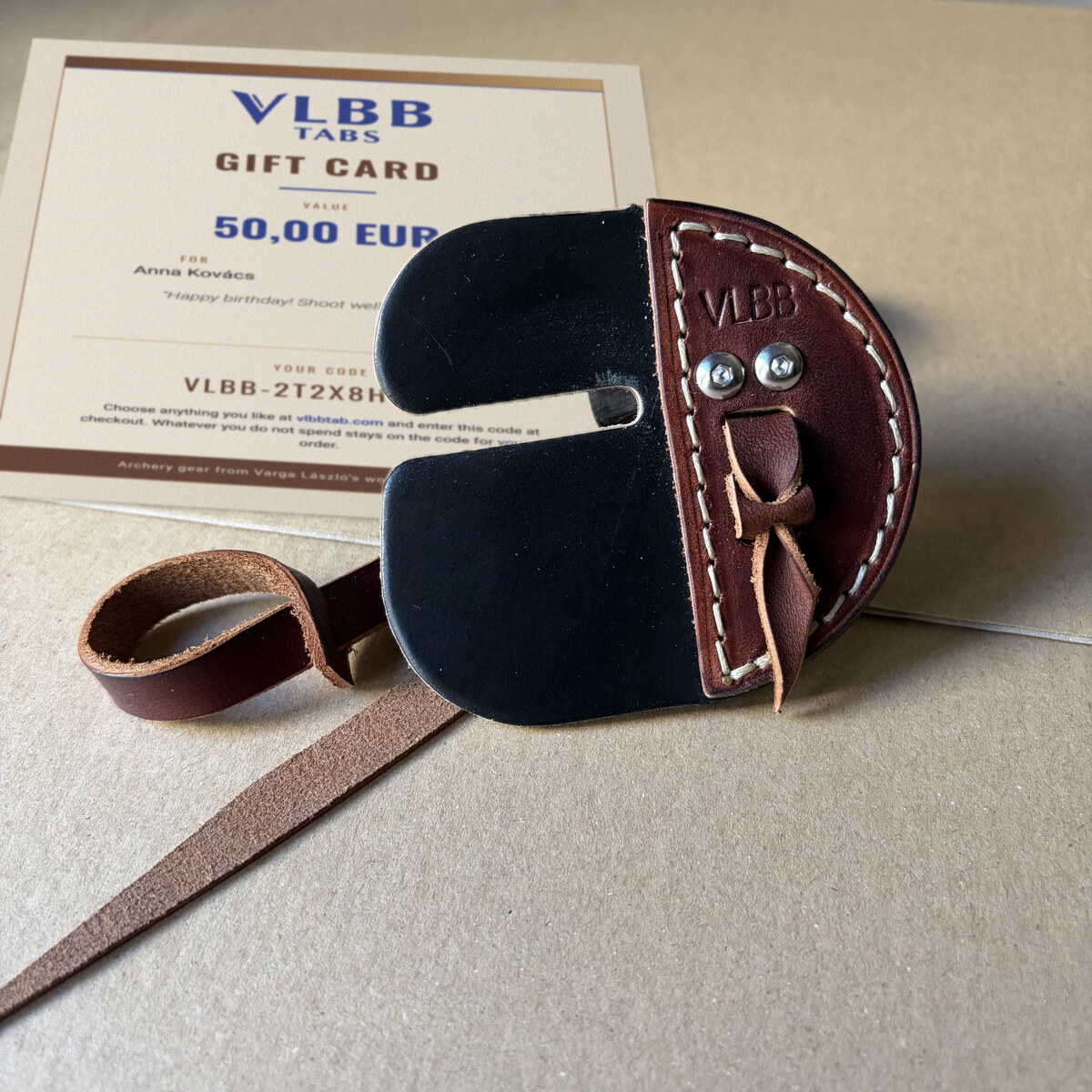 Printed VLBB gift card next to a leather archery tab